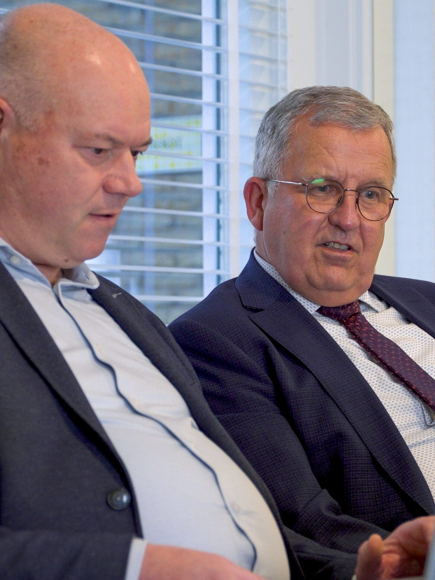 Twee collega's van telt overleggen achter een laptop